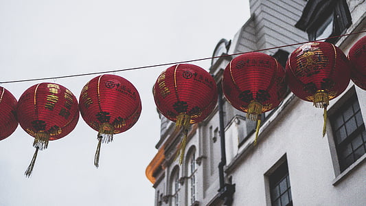 red paper lantern hanged on string near building thumbnail