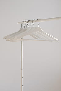 six white clothes hangers on white clothes rack thumbnail