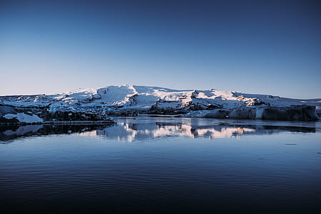 snow covered mountain near body of water thumbnail