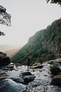 man standing beneath the cliff thumbnail