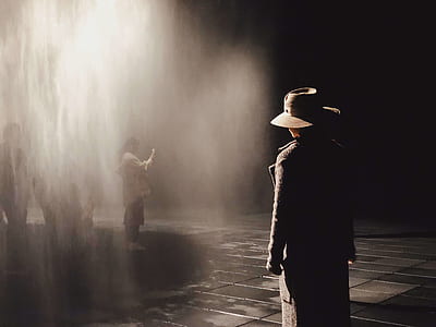 person wearing black coat standing near woman with light passing through thumbnail