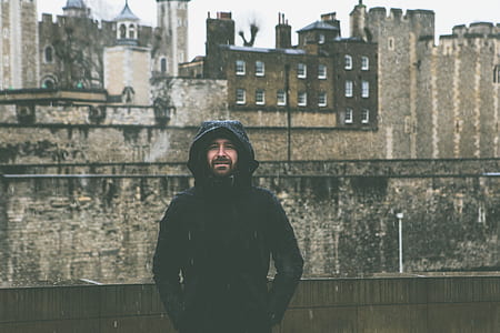 man wearing black hoodie standing in front of wall thumbnail