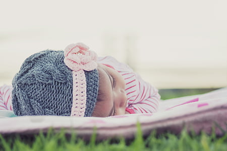 baby's wearing gray knitted cap and pink footies thumbnail