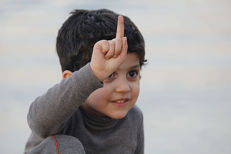 child in long sleeve shirt pointing at the sky thumbnail