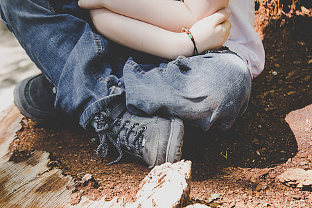 person sitting on soil while carrying baby during daytime thumbnail
