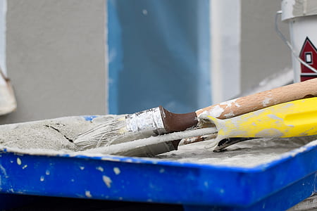 closeup photo of brown and white paint brush on yellow plastic tray thumbnail