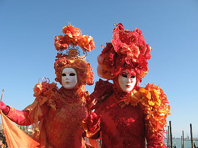 two person wearing red and orange costume with white mask during daytime thumbnail