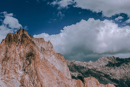 brown mountain under white and blue skies thumbnail