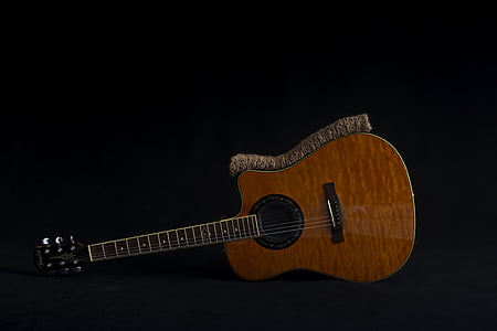 brown steel string guitar on floor thumbnail
