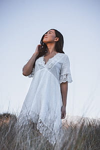 low angle photo of woman standing on grass field thumbnail