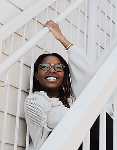 woman sitting on white stair during daytime thumbnail