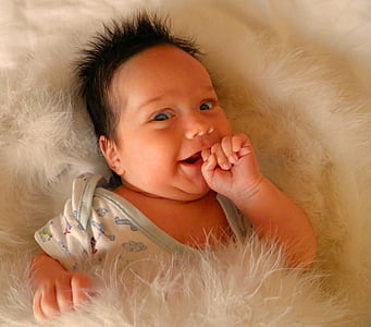 baby under white fur blanket thumbnail