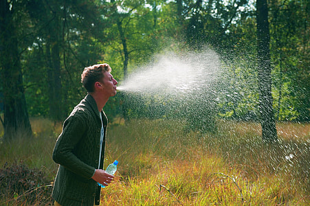 man holding plastic water bottle during daytime thumbnail