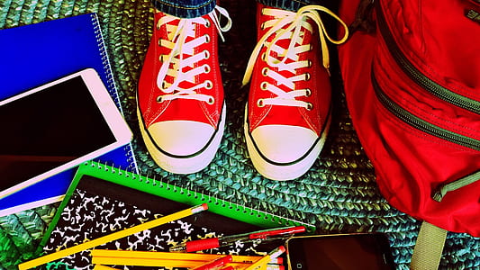 pair of red-and-white low-tops; books; pencils; smartphone; bag thumbnail
