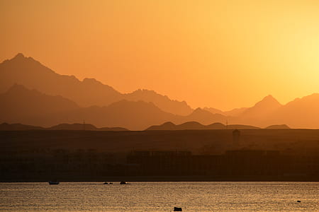 silhouette photography of mountain and building thumbnail