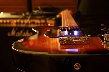 brown telecaster guitar in front of black Marshall guitar amplifier thumbnail