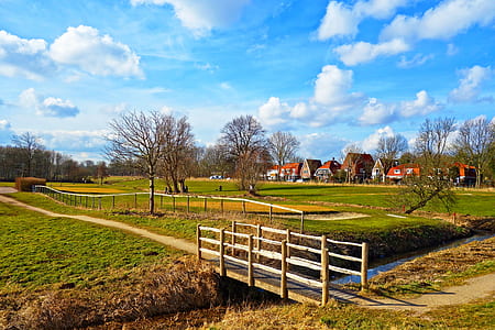 brown wooden bridge under white and blue skies thumbnail