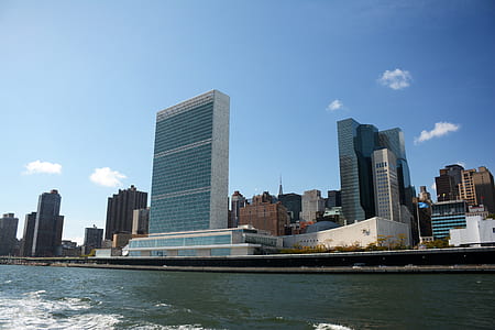 high rise building near body of water under blue sky thumbnail