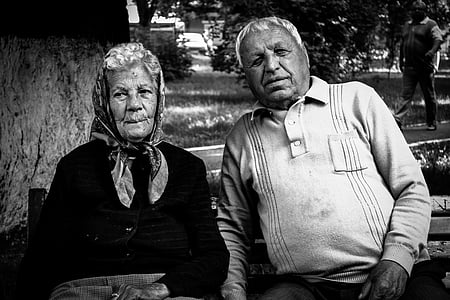 woman and man sitting on bench in grayscale photography thumbnail