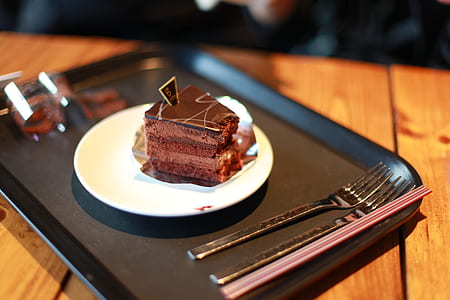 sliced chocolate cake on white ceramic saucer and tray thumbnail