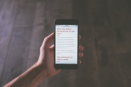 person holding smartphone showing article thumbnail