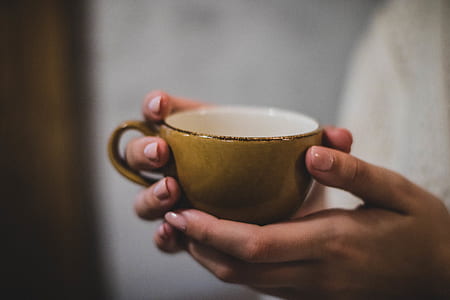 Person Holding Yellow Ceramic Cup thumbnail