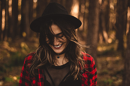 woman smiling under shade of trees in woodlands at daytime thumbnail