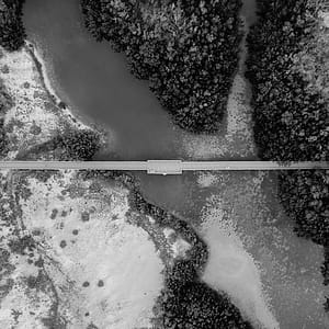High-angle and Grayscale Photography of Road and Body of Water thumbnail