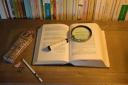 book with magnifying glass, pencil and Egyptian sarcophagus figurie thumbnail