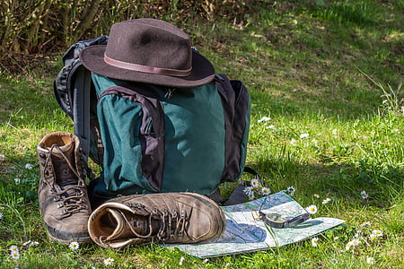 black and green backpack and Fedora hat on green grassland thumbnail