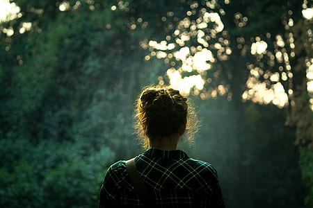 woman in white and green plaid shirt near trees thumbnail