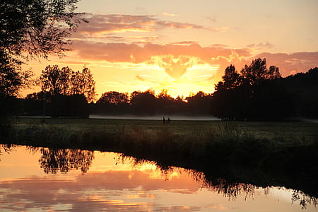 silhouette photo of body of water surrounded with trees thumbnail