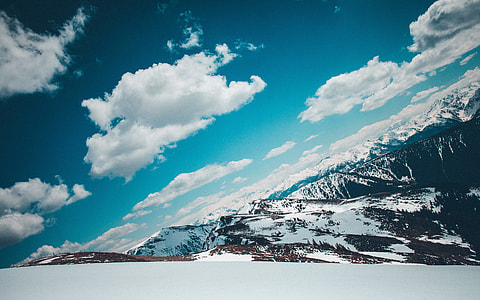 cloudy sky above snow covered mountain at daytime thumbnail