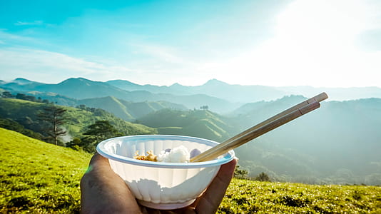 person holding white ceramic bowl with chopsticks thumbnail