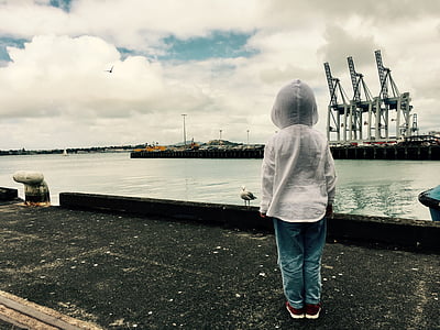 boy wearing hoodie standing on dock thumbnail