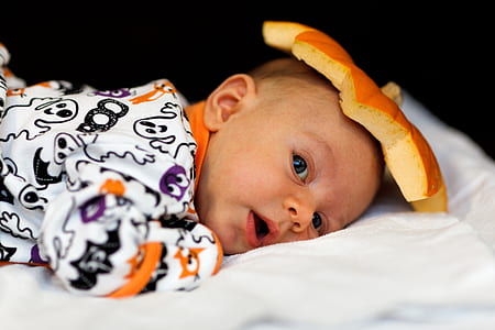baby lying on white bed thumbnail