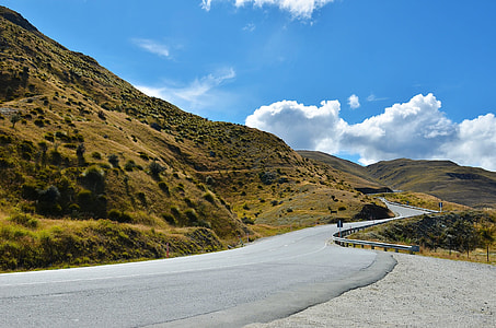 gray asphalt road beside mountain hill d thumbnail