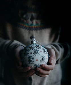 round white Christmas bauble on human hands thumbnail