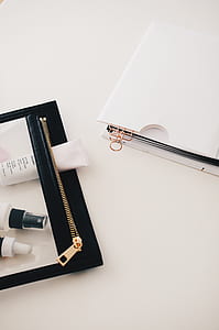 white soft tube bottle in black purse thumbnail