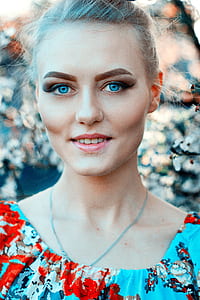 woman wearing blue, red, and black floral top thumbnail