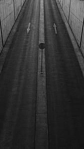 grayscale photography of signage in between asphalt road thumbnail