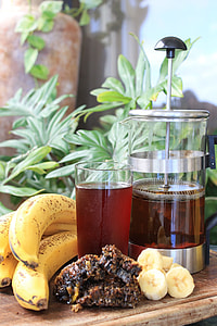 filled drinking glass beside bunch of yellow banana thumbnail