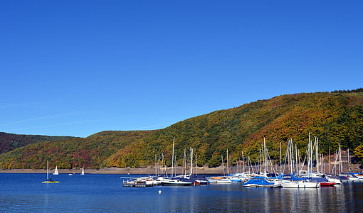 white boats near mountain at daytime thumbnail