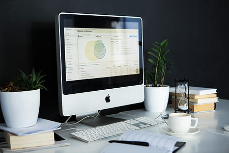 silver iMac near the white keyboard and a cup of coffee thumbnail