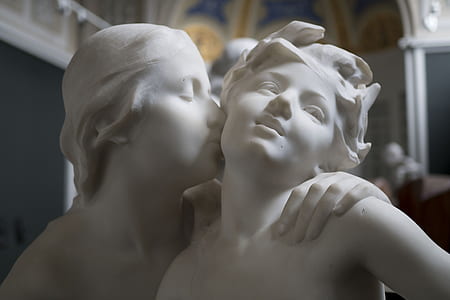 man and woman kissing statue inside room thumbnail