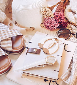 round gold-colored analog watch with white leather trap near pair of white dangle earrings thumbnail