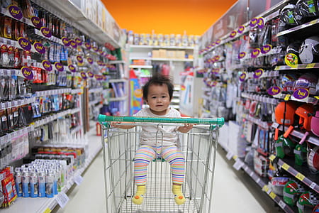 shallow focus photography of baby on grocery cart in store pathway thumbnail