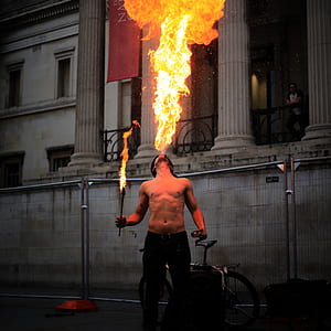 man blowing fire near concrete building thumbnail