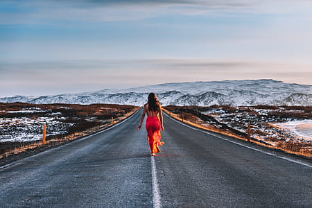 woman wearing red dress walking on a blacktop road thumbnail