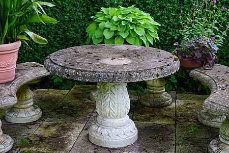 round grey concrete pedestal table with benches and plants thumbnail